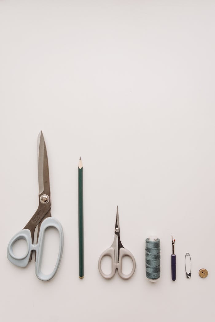 our-services-2 Minimalist photo of essential sewing tools neatly arranged on a neutral background.
